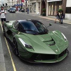 a green sports car is parked on the street