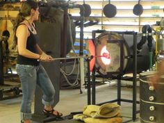 a woman standing in front of an oven with a large flame coming out of it