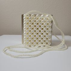 This stunning crossbody handbag is crafted with delicate pearl design and pearl straps. Enjoy effortless style and endless compliments with this elegant bag. Feel beautiful and confident with the perfect accessory for your look. Chic Pearl Embellished Shoulder Bag For Party, White Evening Shoulder Phone Bag, Chic White Phone Bag, Elegant Crossbody Evening Bag With Pearl Handle, Elegant White Phone Bag For Everyday Use, Elegant Shoulder Phone Bag As Gift, Chic Pearl Clutch For Formal Occasions, Chic White Evening Phone Bag, Chic Evening Pearl Shoulder Bag