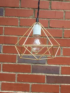 a light fixture hanging from the side of a brick wall