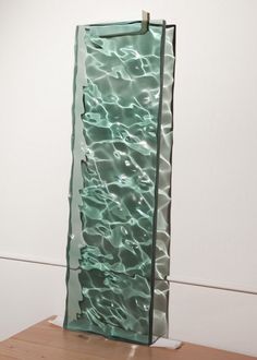 a glass sculpture sitting on top of a wooden table