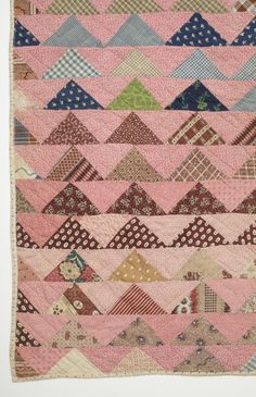 an old quilt with many different colors and patterns on it's sides, including pink