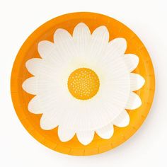 an orange and white paper plate with a flower on the center, in front of a white background