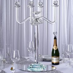 a candelabra that is sitting on a table with wine glasses and champagne