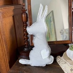 a white rabbit figurine sitting on top of a table next to a mirror