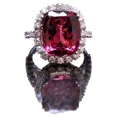 DeKara Designs Collection Metal- 18K White Gold, .750. Stones- Cushion Pinkish Red Tourmaline 8.40 Carats, 32 Round Diamonds, F-G Color VS1-VS2 Clarity, 1.20 Carats. Size- Ring is a 6 1/2. FREE SIZING!!!! A Breathtaking Luxurious 18K White Gold Tourmaline Halo Diamond Engagement/Wedding. This ring is entirely handmade with a exceptional cushion cut reddish pink colored tourmaline. The tourmaline is professionally set in between four prongs and surrounded by 20 French U pave set round diamonds. Each side of the ring has another six round French U pave set diamonds to give the ring a dazzling finish. The gallery work on the ring is amazing with wires running up from the ring's shank up to the halo portion. The ring is one of a kind! A truly dazzling heirloom piece that will be loved by all! Tourmaline Engagement Ring, Red Tourmaline, Contemporary Engagement Rings, Pinkish Red, Modern Engagement Rings, Gold Cocktail Ring, Art Deco Engagement, Diamond Cocktail Rings, Gold Halo