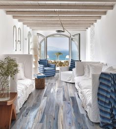 a living room filled with white furniture and lots of windows