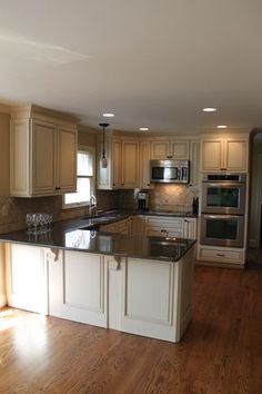 a large kitchen with an island in the middle and two wine glasses on the counter