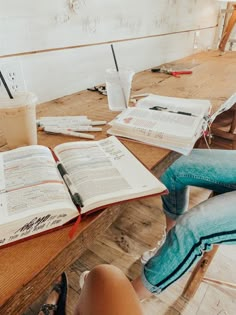 an open book sitting on top of a wooden table next to a cup of coffee