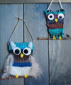 two knitted owls hanging from hooks on a wooden wall next to another owl ornament