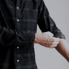 a man wearing a black and white checkered shirt with his hands on his hips