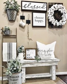 a white bench sitting next to a wall filled with pictures and plants on top of it