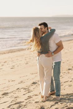 a man and woman kissing on the beach