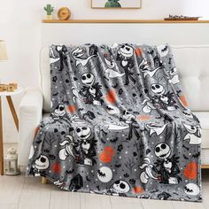 a living room with a couch covered in a halloween themed blanket