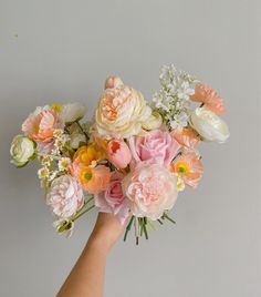 a person's hand holding a bouquet of flowers