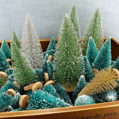 small christmas trees are in a wooden container