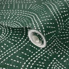 a green and white wallpaper with small dots on the fabric, which is very large