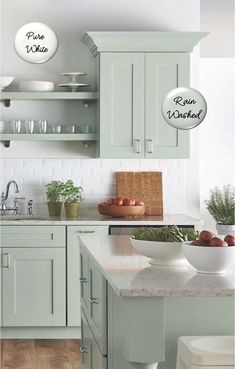 a kitchen with green cabinets and white counter tops, two bowls are on the island