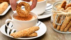 someone dipping pretzels into a cup of coffee