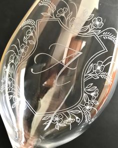 a wine glass with the letter f etched into it's bottom and sides, sitting on a black surface