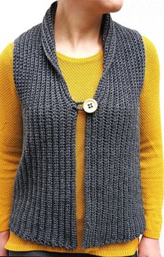 a woman wearing a gray knitted vest with a button on the front and side