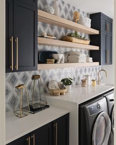 a washer and dryer in a room with shelves above the washer door