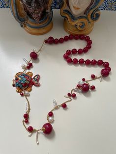 ✔️Sicilian style necklace! Made with string of red Agate faceted pearls, individually knotted, gold plated stainless steel chain, natural freshwater pearls and scaramazza pearls and small smooth red agate pearls. The lively jewel is completed by a hand-painted Caltagirone ceramic fish. Wear beautiful Sicily and always carry it with you with this unique necklace! ✔️DETAILS: 🟩 Materials: Agate Stainless steel Gold River pearls Scary pearls Caltagirone ceramics 🟧🟧Dimensions: Necklace length 85 c River Pearls, Gold River, Ceramic Fish, Red Agate, Unique Necklaces, Natural Pearls, Steel Chain, Necklace Length, Stainless Steel Chain