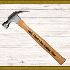 a hammer with the words dad thanks for making man written on it and a wooden background