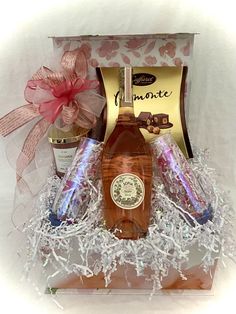 a bottle of wine in a gift box with some confetti and chocolates