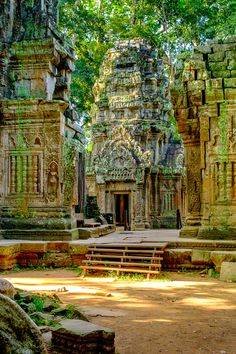 an ancient temple in the middle of a forest filled with trees and other large stone structures