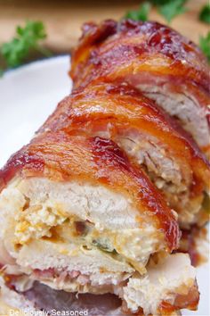 a close up of a plate of food with meat wrapped in bacon and sauces