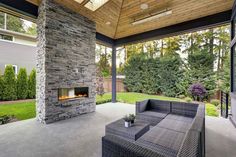 an outdoor living area with couches and a fire place in the middle of it