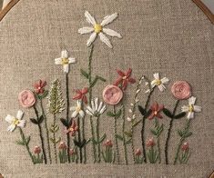 a close up of a embroidery on a piece of cloth with flowers in the middle