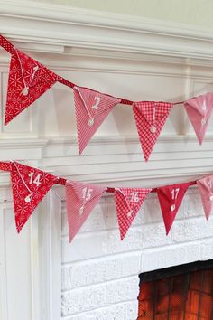 red and white buntings hanging from a fireplace mantle in front of a fire place