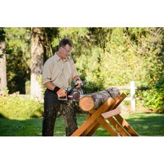 a man using a chainsaw to cut logs