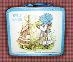 an old tin lunch box with two children's clothes on it and the words holly hubbie