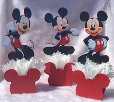 three mickey mouse cupcakes are on display