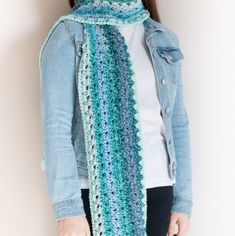 a woman wearing a blue and green crocheted scarf