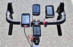 there are three electronic devices attached to the handlebars of a bike that is parked on the street