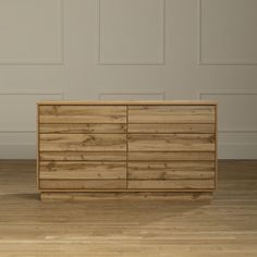 a wooden dresser sitting on top of a hard wood floor next to a white wall