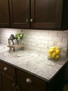 an image of a kitchen counter top with lemons in the bowl and ice white