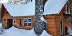 a log cabin with snow on the roof