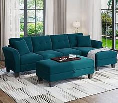 a living room scene with focus on the sectional sofa and footstool in the middle