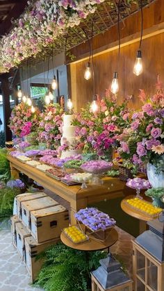 a flower shop filled with lots of flowers and lights hanging from the ceiling above it