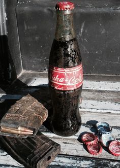 an old coca - cola bottle sitting on top of a window sill next to some coins