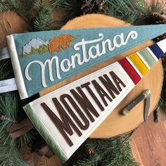 the montana flag is hanging on a christmas tree with pine needles and other things around it