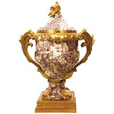 an ornately decorated urn with gold trimmings on the top and sides