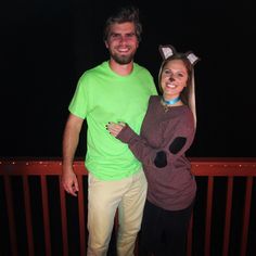 a man and woman dressed up in costumes posing for a photo on a balcony at night