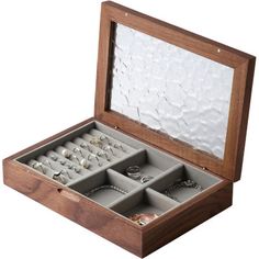 an open wooden box with rings and bracelets in it