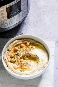 a bowl of hummus next to an instant pot